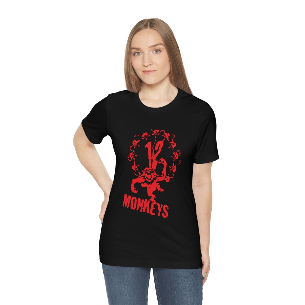 Woman wearing a very comfortable black 12 monkeys shirt with red graphics to wear at your favorite convention